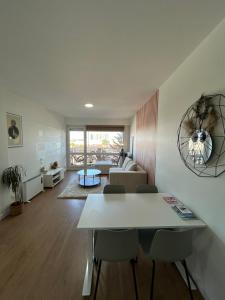 a living room with a white table and chairs at Appartement moderne avec parking privé Lit connecté LED & rétroprojecteur 5 min Zénith in Saint-Herblain