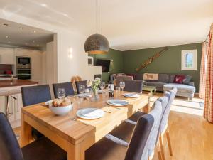 a dining room and living room with a wooden table and chairs at Villa Taube XL in Bad Gastein