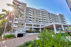 a building with a palm tree in front of it at Spacious Darwin Esplanade Retreat with Pool & Spa in Darwin