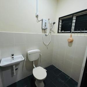 a bathroom with a toilet and a sink at Homestay D'Aina in Teluk Intan +4 photos