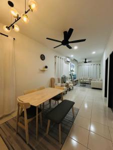 a living room with a table and a ceiling fan at Homestay D'Aina in Teluk Intan