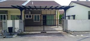 a gate in front of a house with a fence at Homestay D'Aina in Teluk Intan