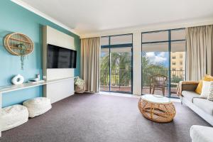 a living room with a couch and a tv at Spacious Darwin Esplanade Retreat with Pool & Spa in Darwin