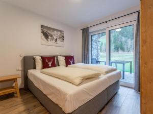 a bedroom with a bed and a large window at Pinzgau Lodge 2B in Wald im Pinzgau