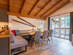a dining room with a table and a couch at Pinzgau Lodge 2B in Wald im Pinzgau