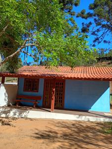a blue and white house with a red roof at Chalé vale do Monte Verde in Camanducaia