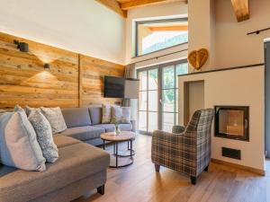 a living room with a couch and a tv at Pinzgau Lodge 1A in Wald im Pinzgau