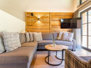 a living room with a couch and a tv at Pinzgau Lodge 1A in Wald im Pinzgau