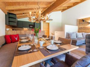 a dining room with a table and a couch at Pinzgau Lodge 2E in Wald im Pinzgau