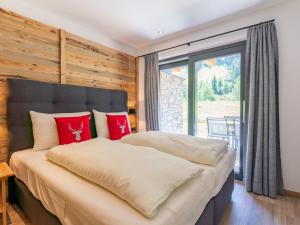 a bedroom with a large bed with red pillows at Pinzgau Lodge 2E in Wald im Pinzgau