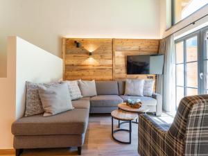 a living room with a couch and a tv at Pinzgau Lodge 2E in Wald im Pinzgau