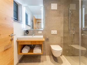 a bathroom with a sink and a toilet and a shower at Pinzgau Lodge 2E in Wald im Pinzgau +28 photos