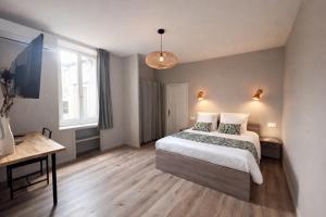a bedroom with a large bed and a desk at LE 139 carcassonne in Carcassonne
