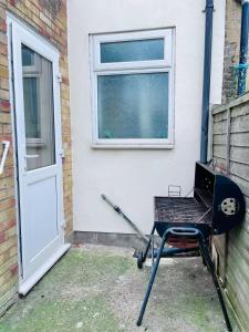a barbecue grill sitting in front of a door at Contractor Accommodation, Free Large Car Park, Sleeps 7 in Kent