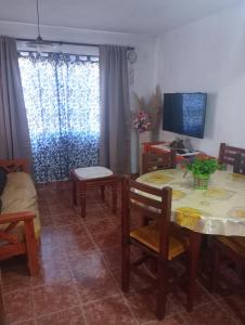 a living room with a table and chairs and a tv at ¡Quien Diria! in San Clemente del Tuyú