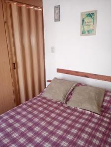 a bedroom with a bed with a plaid blanket at ¡Quien Diria! in San Clemente del Tuyú
