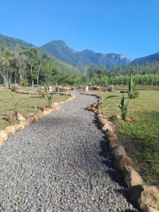 a cobble stone road in a field with mountains in the background at Sombra do baú -Luar in Timbe do Sul +4 photos