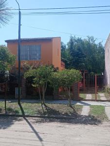 a building with a fence and trees in front of it at ¡Quien Diria! in San Clemente del Tuyú
