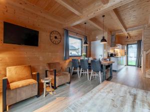 a living room with a dining room and kitchen with a clock on the wall at Rattendorf 21A in Rattendorf