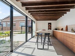 an open kitchen with a table and large windows at Pastorie Liezele in Puurs