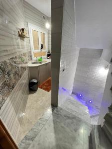 a bathroom with a walk in shower and a sink at Great duplex in Monastir in Monastir +14 photos