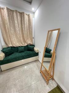 a living room with a green couch and a mirror at Great duplex in Monastir in Monastir