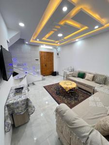 a living room with couches and a tv and a table at Great duplex in Monastir in Monastir