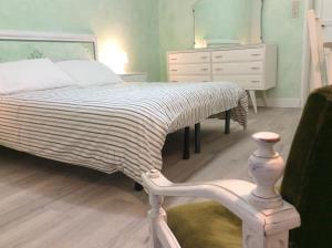 a bedroom with a bed and a dresser and a chair at Le Camere di Casa Cassandra in Perugia