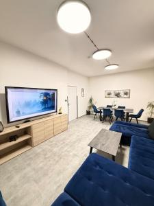 a living room with a blue couch and a flat screen tv at Teplice Apartments 2 in Teplice