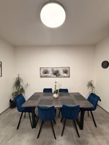 a dining room with a wooden table and blue chairs at Teplice Apartments 2 in Teplice