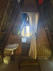 a bathroom with a sink and a bed in a room at Lumindas Beach Resort in Sabang