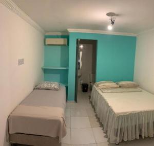 a room with three beds and a blue wall at 14km de tambau in Cabedelo