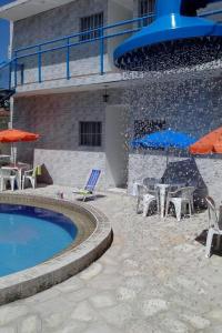 a pool with chairs and umbrellas next to a building at 14km de tambau in Cabedelo