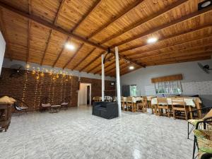 a large room with tables and chairs and wooden ceilings at Quinta La Soñada eventos luján in Luján