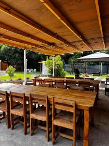 a large wooden table and chairs under a pavilion at Quinta La Soñada eventos luján in Luján
