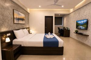 a hotel room with a bed and a desk at Harvey's Brookefield-With Free Car Parking in Bangalore +14 photos