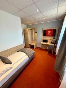 ein Schlafzimmer mit einem großen Bett und einem Schreibtisch in der Unterkunft Hotel Vorburg - Free Parking - Bei Hamburg in Trittau + 7 Fotos