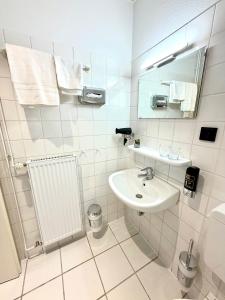 ein weißes Badezimmer mit Waschbecken und Spiegel in der Unterkunft Hotel Vorburg - Free Parking - Bei Hamburg in Trittau