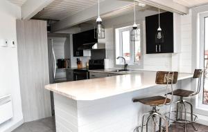 a kitchen with black cabinets and a white counter top at Mont Ste-Anne Chalet in Beaupré