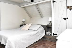 a bedroom with a white bed and two lamps at Mont Ste-Anne Chalet in Beaupré
