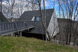 a house with a deck on the side of it at Mont Ste-Anne Chalet in Beaupré