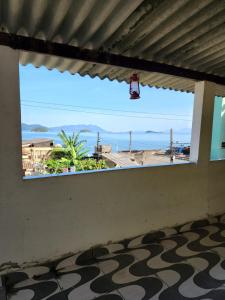 a view of the beach from a room with a window at Recanto na Praia com Vista Mar in Mangaratiba