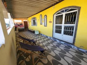 a room with two chairs and a building with a door at Recanto na Praia com Vista Mar in Mangaratiba