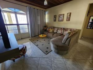 a living room with a couch and a table at Recanto na Praia com Vista Mar in Mangaratiba