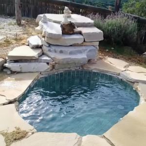a small pond with a fountain in a yard at Ecovalle São Thomé - Chalé do Sol in São Thomé das Letras