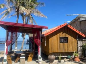 a shack on the beach with palm trees at INS n OUTZ in Bolinao