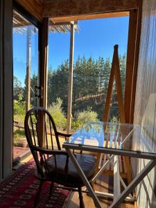 a glass table and a chair on a porch with a window at Converted Farm Loft in Casablanca