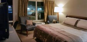 a hotel room with a bed and a chair and a window at Rolling Hills Lodge in Cherokee