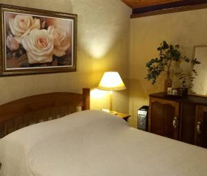 a bedroom with a bed and a picture of roses at Rio Privativo, Piscina e Starlink - Casa Terras de Minas in Gonçalves
