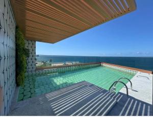 a swimming pool with a bench and a wooden roof at VISTA MAR SPOT Barra in Salvador